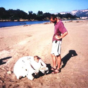 Em and Dad exploring an elephant skull along the river